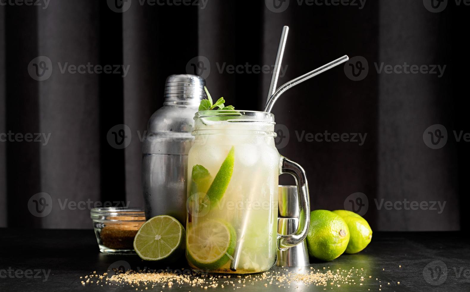 frisse zomerse caipirinha-cocktail op een zwarte gordijnachtergrond foto