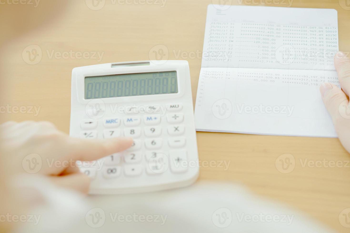 vervagen zakenvrouw gebruik rekenmachine naast bankboekje foto