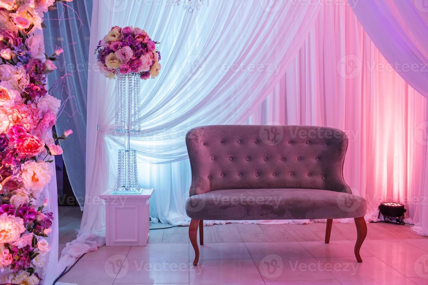 bruiloft decor met klassieke retro bank en witte, roze bloemen. foto