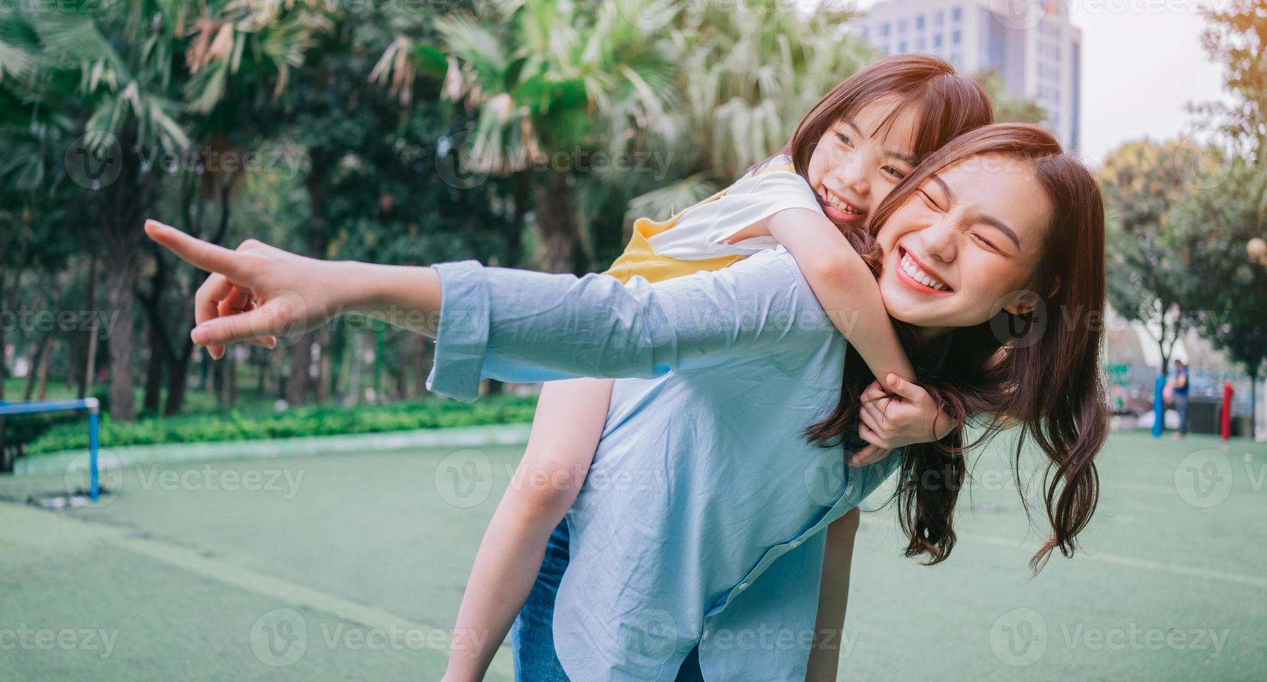 Aziatische moeder en dochter spelen samen in het park foto