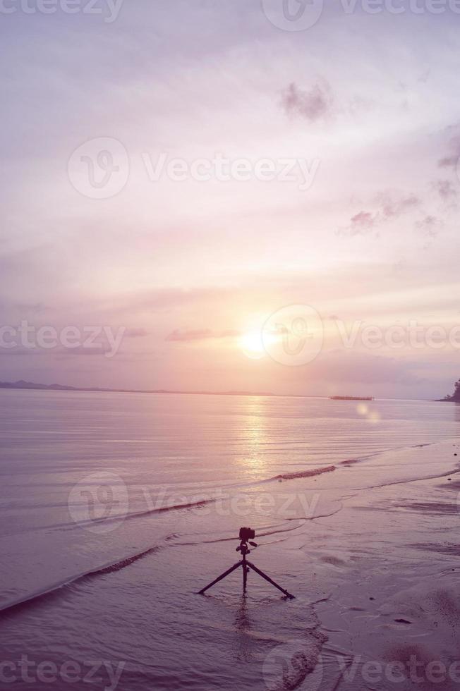 stel de camera en de zee in om de zonsondergang te zien foto