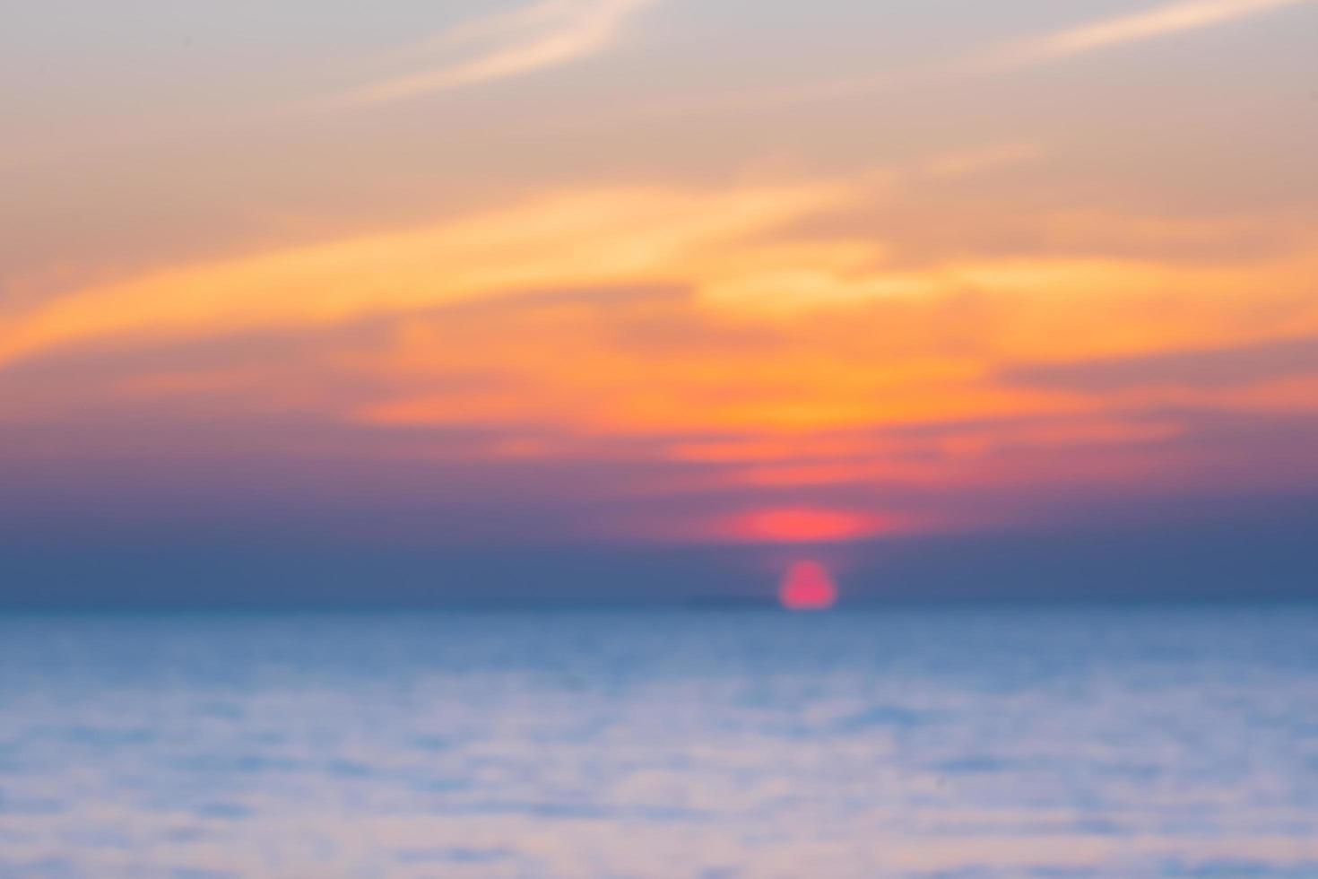 wazig van tropische kleurrijke zonsondergang over de oceaan op het strand. op thailand toerisme achtergrond met zee strand. vakantie reis bestemming foto