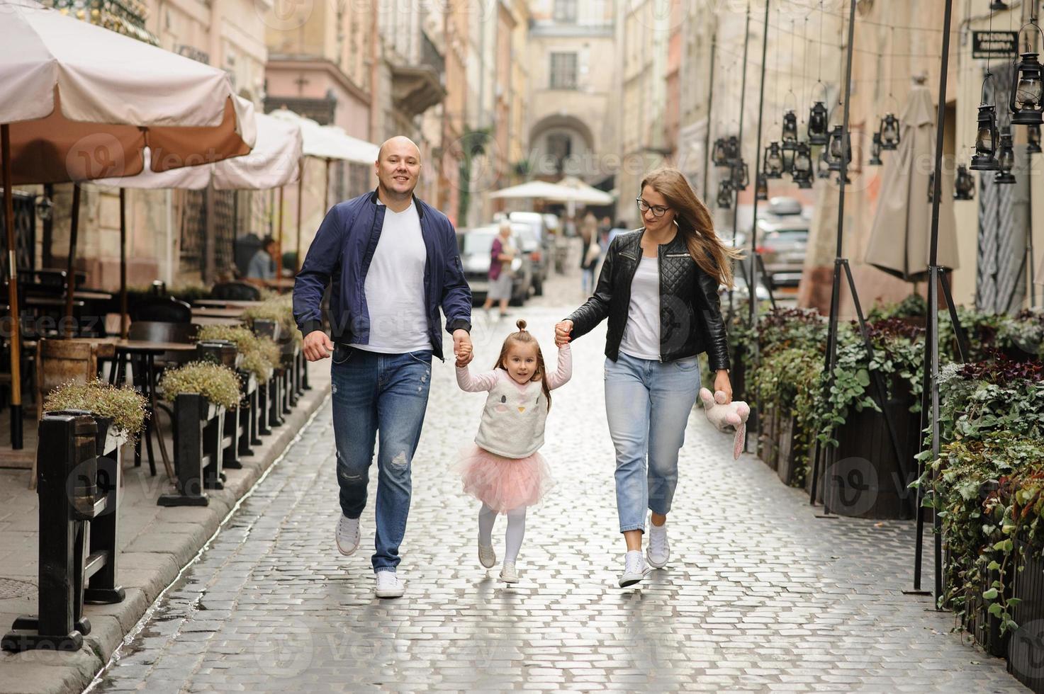 ouders en hun dochter zitten op de trappen van een oude kerk. foto