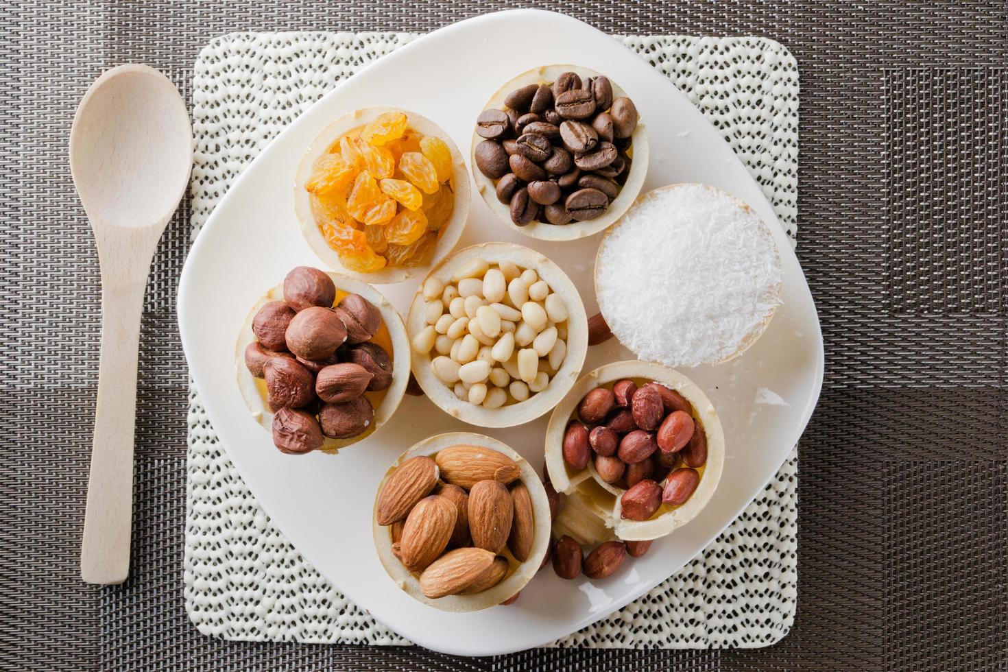 wafelmand met koffiebonen, kokos, rozijnen, amandelen, pinda's, hazelnoten en pijnboompitten foto