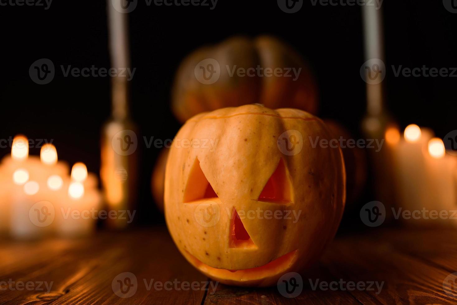 Halloween-pompoen op de achtergrond van kaarsen en een zwarte achtergrond. foto