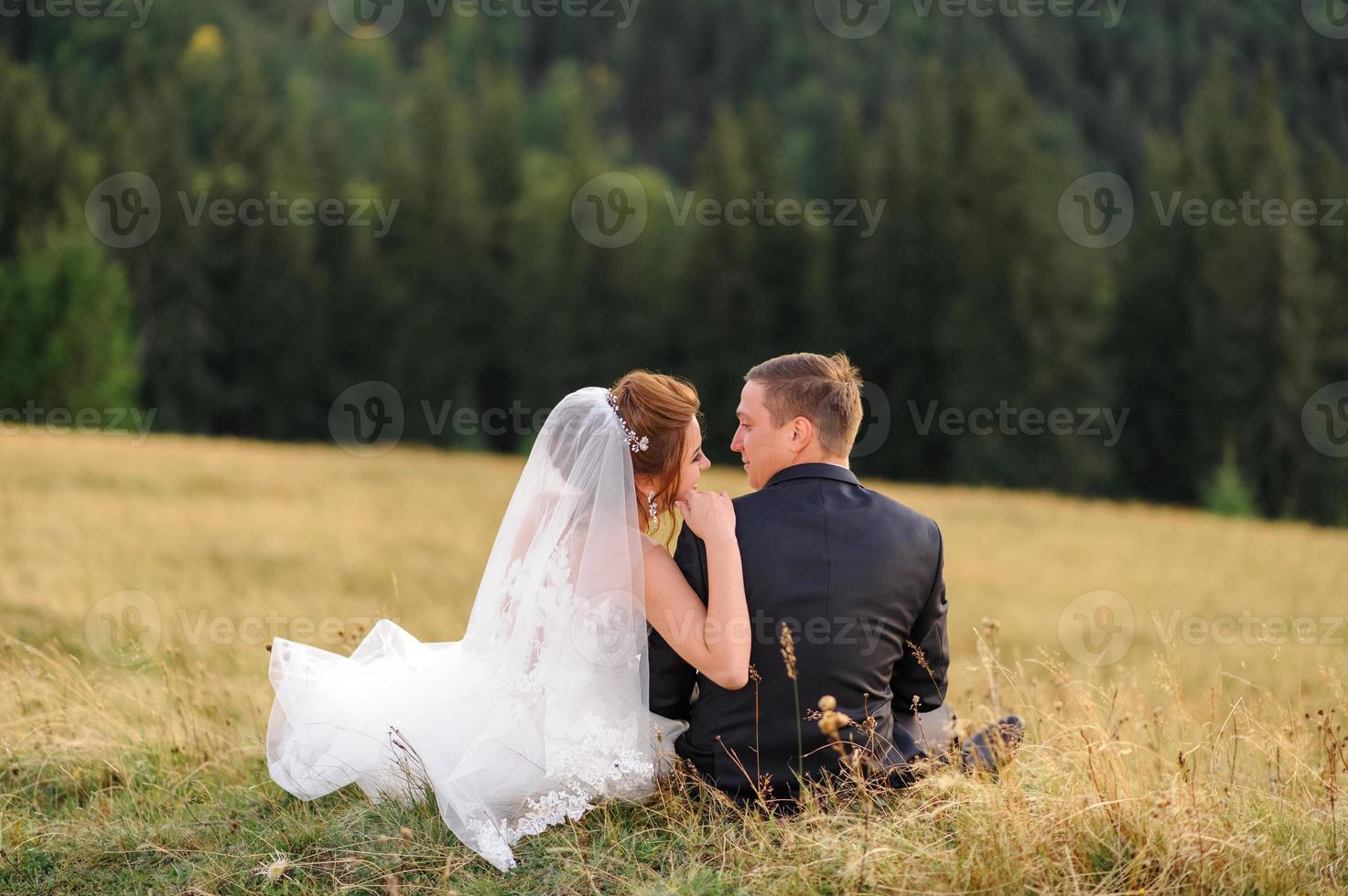 huwelijksfotografie in de bergen. de bruid en bruidegom knuffelen stevig. foto