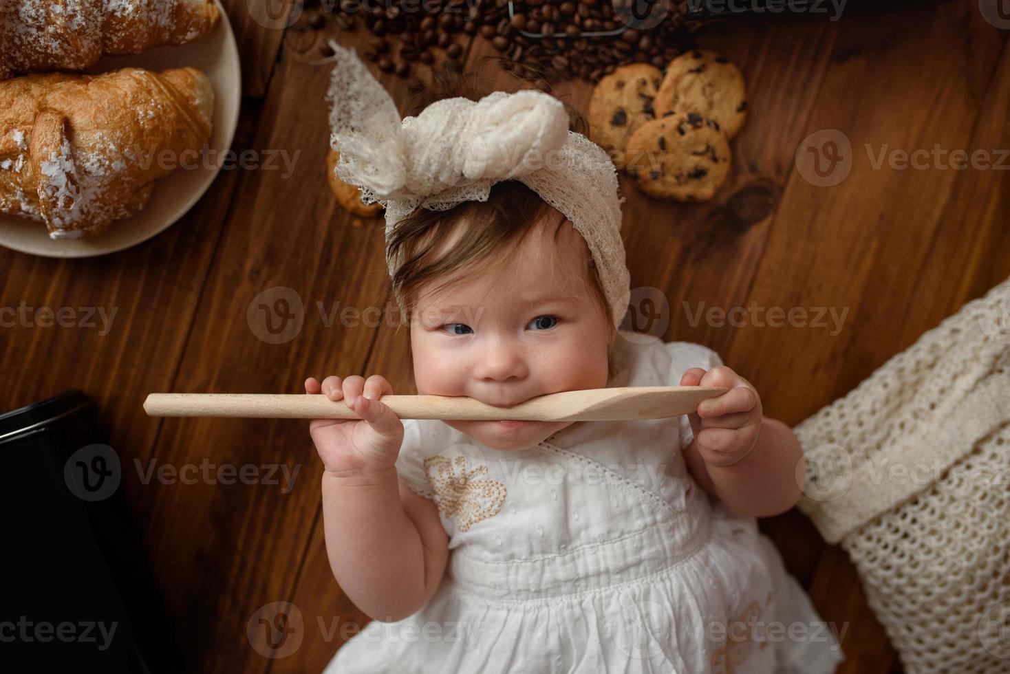 kleine meisjeskok met een houten lepel bereidt de lunch voor. foto