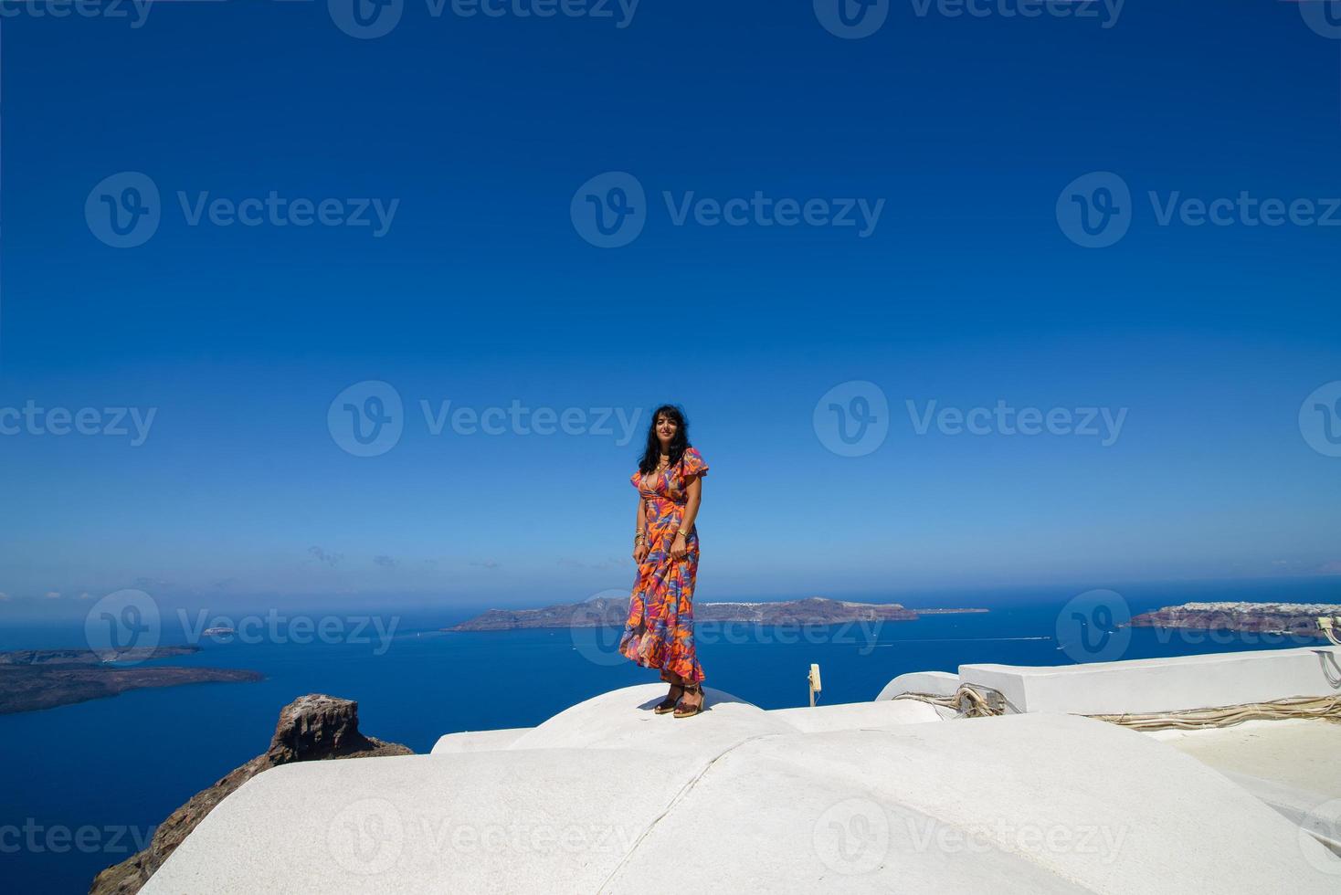 een man en een vrouw knuffelen tegen de achtergrond van skaros-rots op het eiland santorini. het dorp Imerovigli. foto