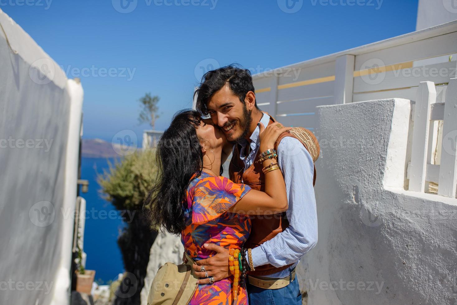 een man en een vrouw knuffelen tegen de achtergrond van skaros-rots op het eiland santorini. het dorp Imerovigli. foto