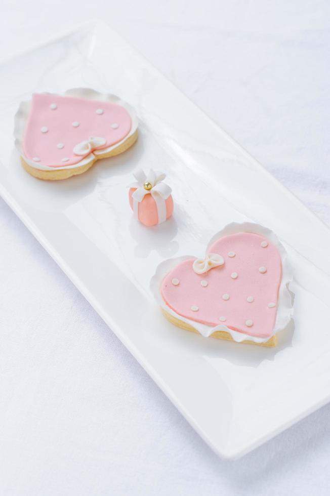 veel roze koekjes op een witte plaat foto