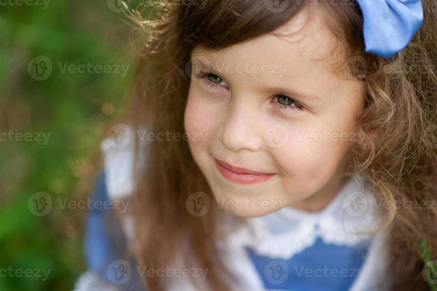 portret van een klein schattig meisje verkleed als Alice. gestileerde fotoshoot in de natuur. foto