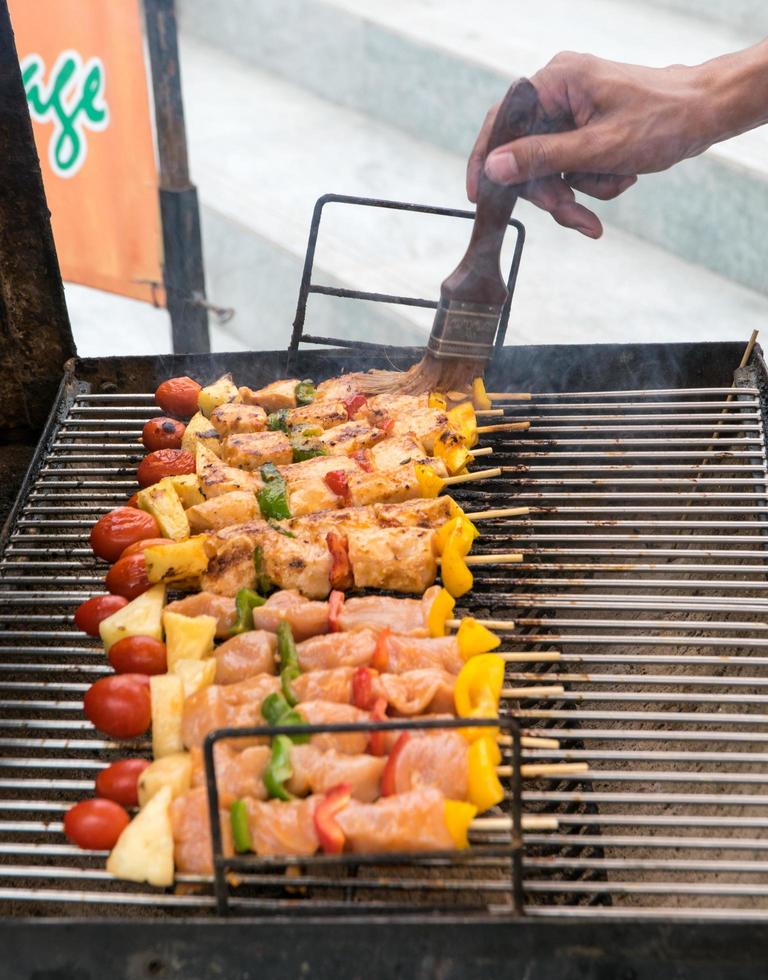 man kookt vlees op barbecue foto