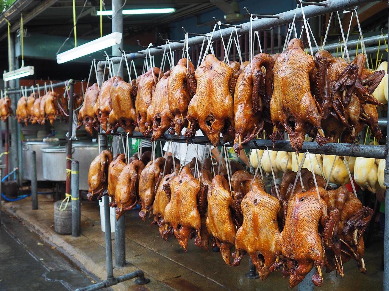 gekookte eend hangend aan de rail te koop op de markt foto