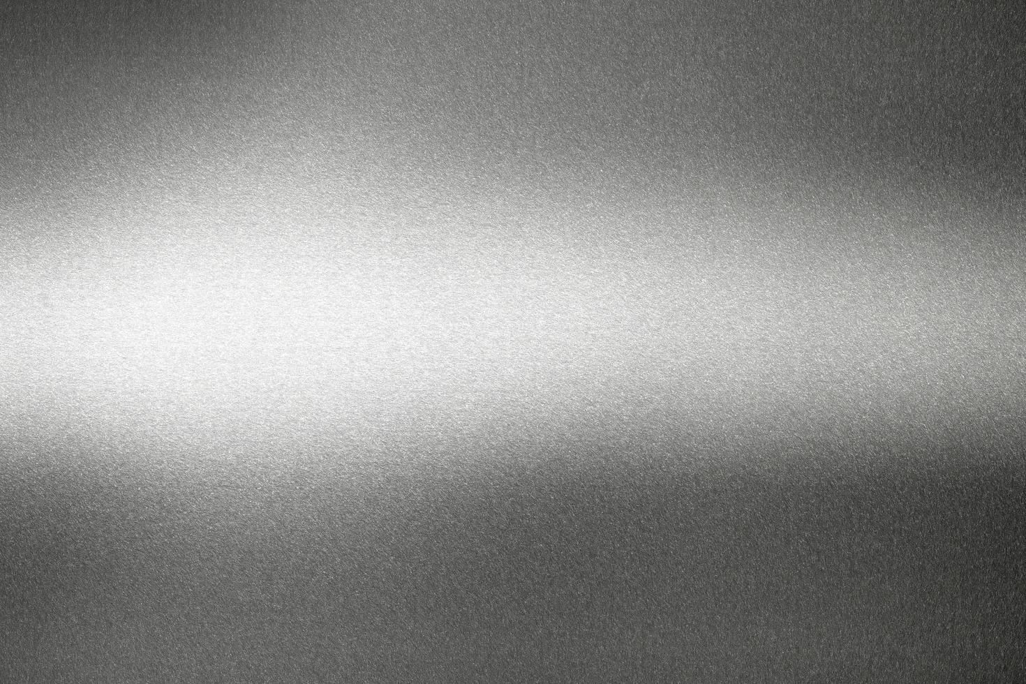 licht schijnt op zwarte metalen wand, abstracte textuur achtergrond foto