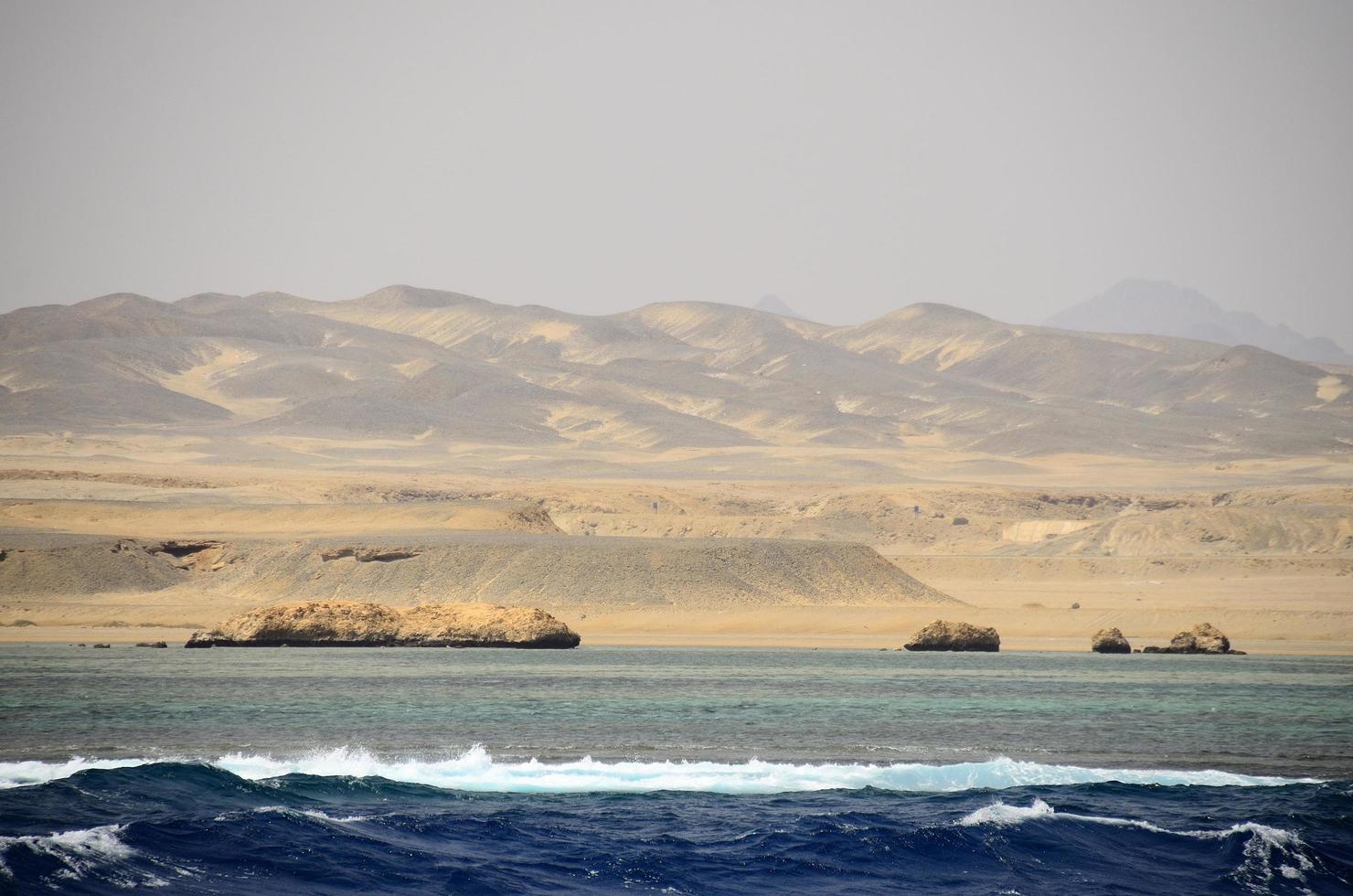 zandwoestijn met zee foto
