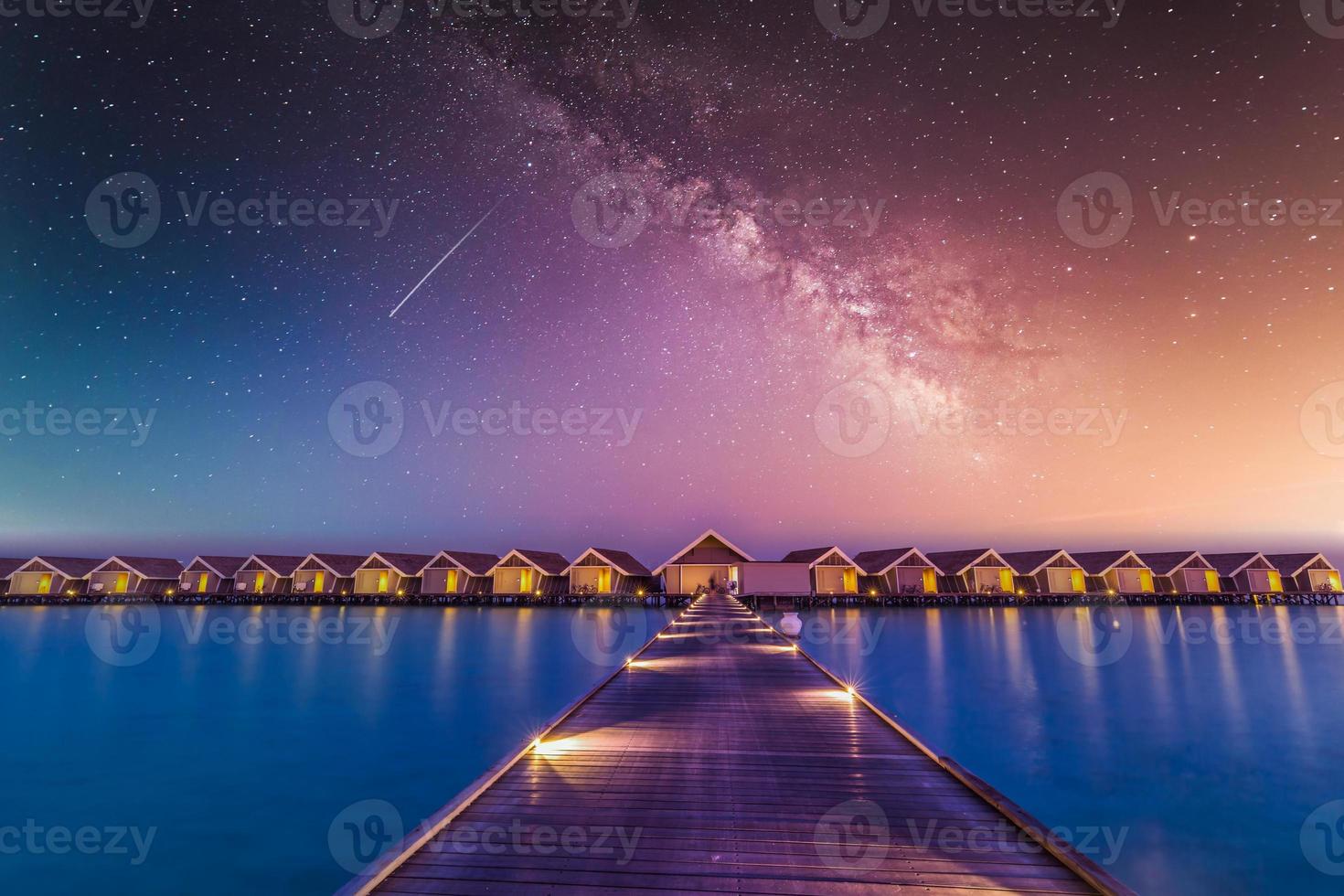 waterbungalows en villa's bij nacht, tropisch landschap. Malediven eilanden luxe villa's 's nachts met melkweghemel en led verlichte steiger. zomervakantie vakantie exotische achtergrond. fantastische natuur foto