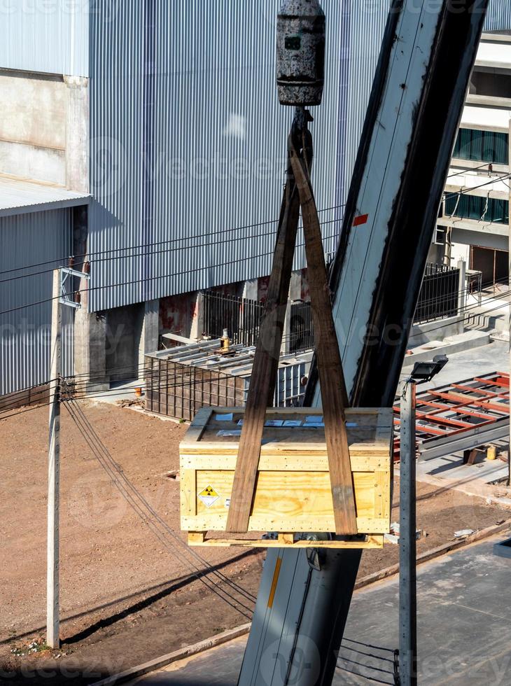 de kraan die de radioactieve instrumenthouder optilt transport houten kist; foto