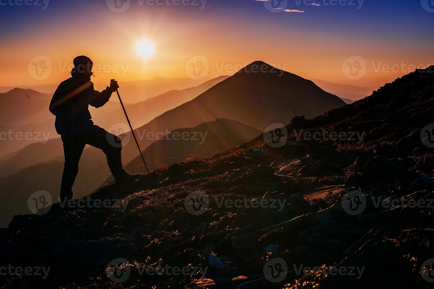 toerist in de bergen bij zonsondergang foto