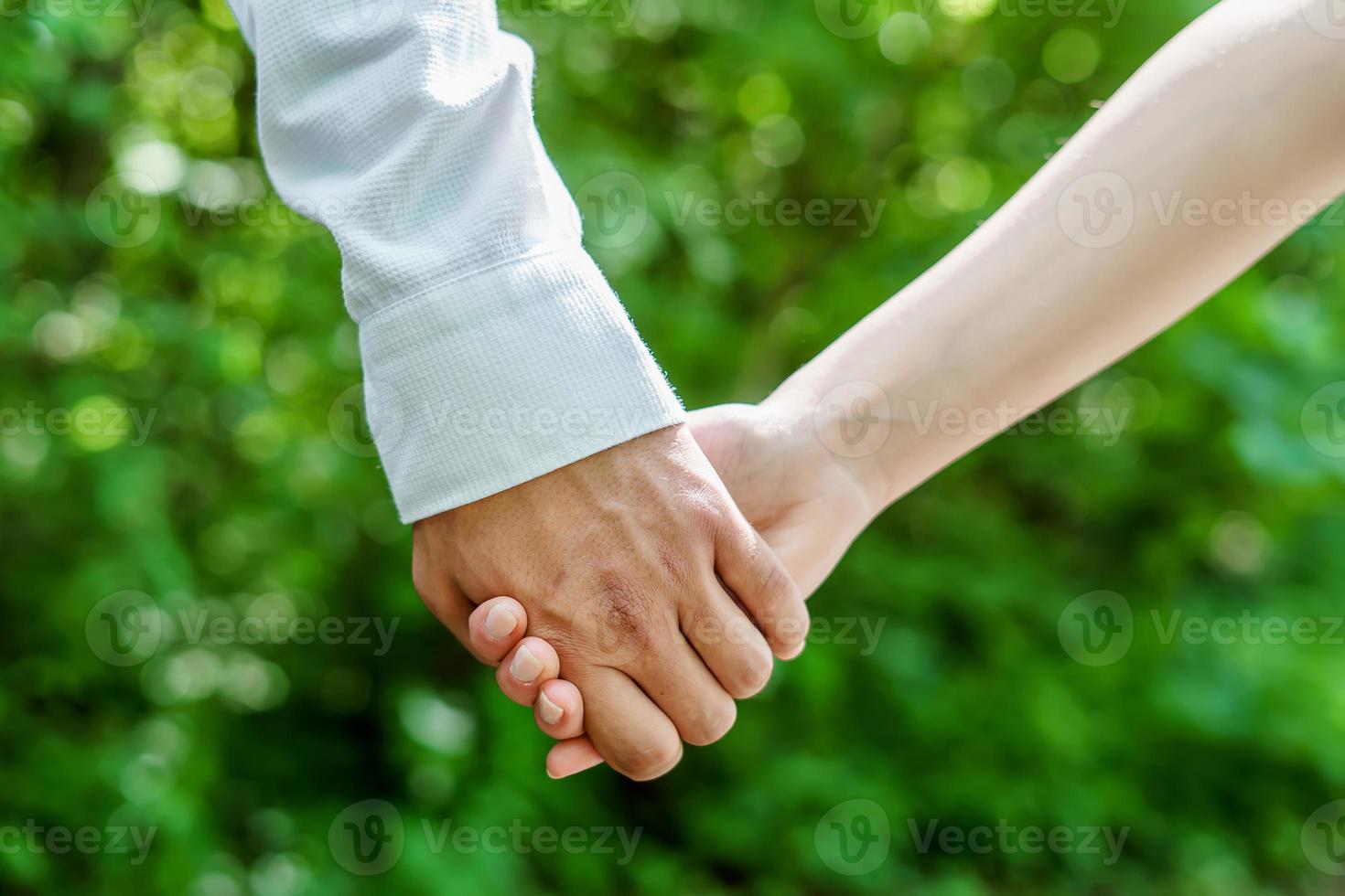 man en vrouw hand in hand op een groene achtergrond foto