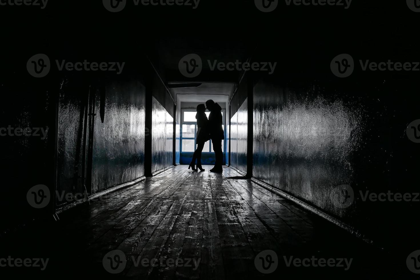 silhouetten van twee geliefden in een donkere gang foto