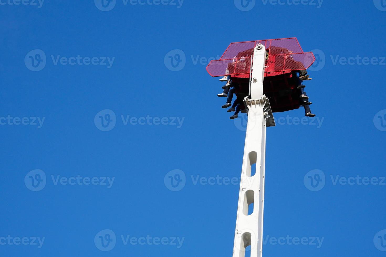 mensen die genieten van een ritje op een vrije val-attractie in lunapark foto