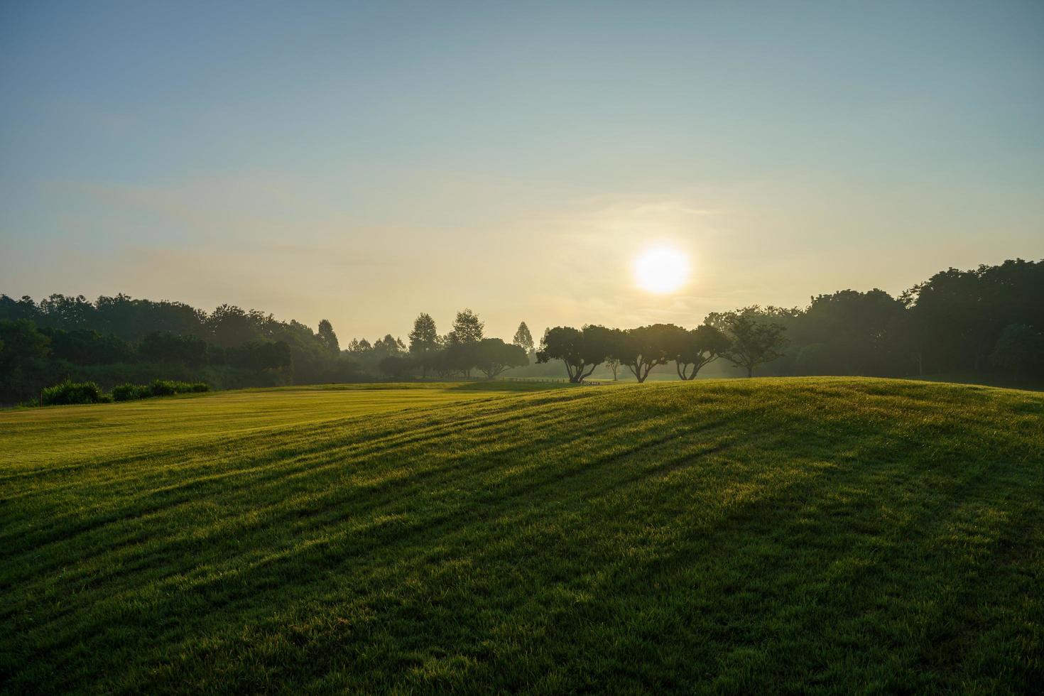 prachtig landschap golfbaan in de ochtendzon opkomt foto