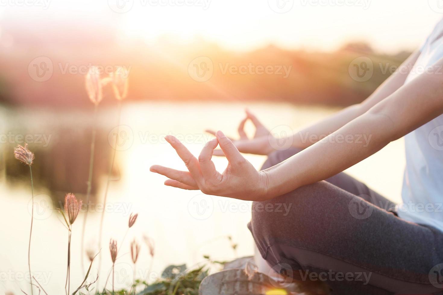 jonge vrouw yoga beoefenen en mediteren aan zee in de zomer achtergrond foto