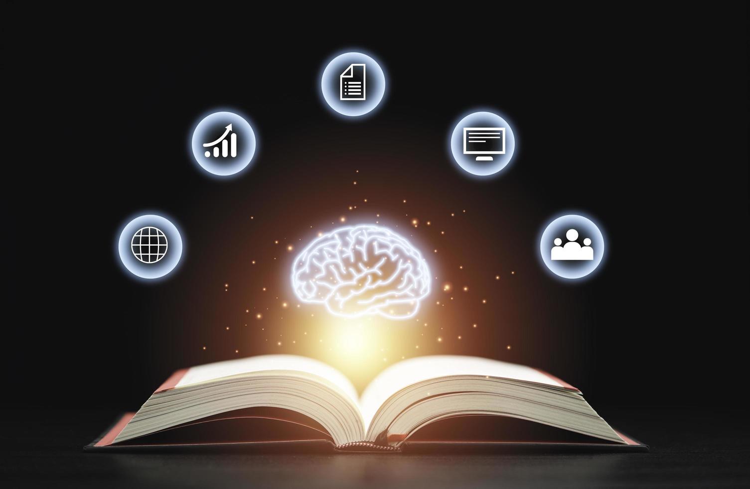 gloeiende virtuele hersenen zweven boven een open boek met leunende pictogrammen op een donkere achtergrond, wat een symbool is van studie, een kennis zal helpen bij het oplossen van probleem- en oplossingsconcept. foto