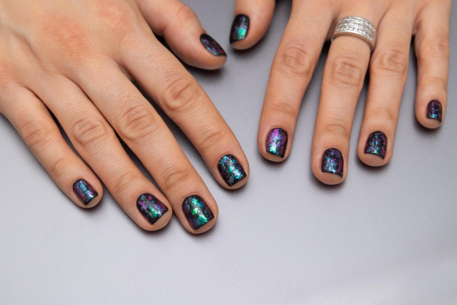 vrouwen goed verzorgde handen met zwarte glitter manicure. gellak coating foto