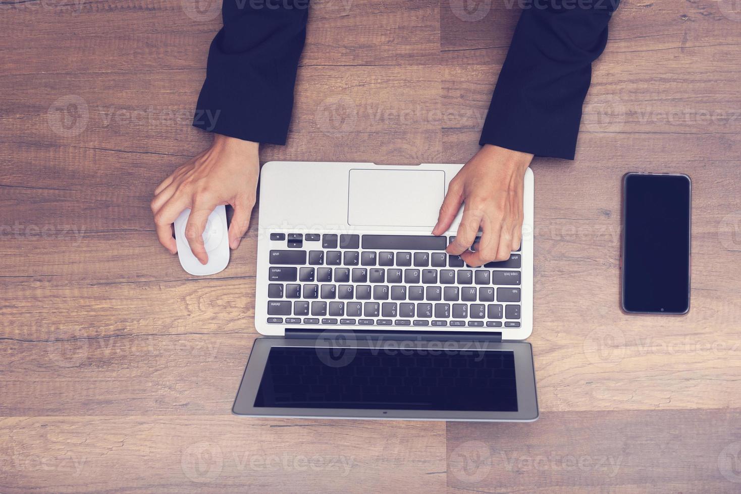 zakenman aan het werk door laptop op houten achtergrond foto