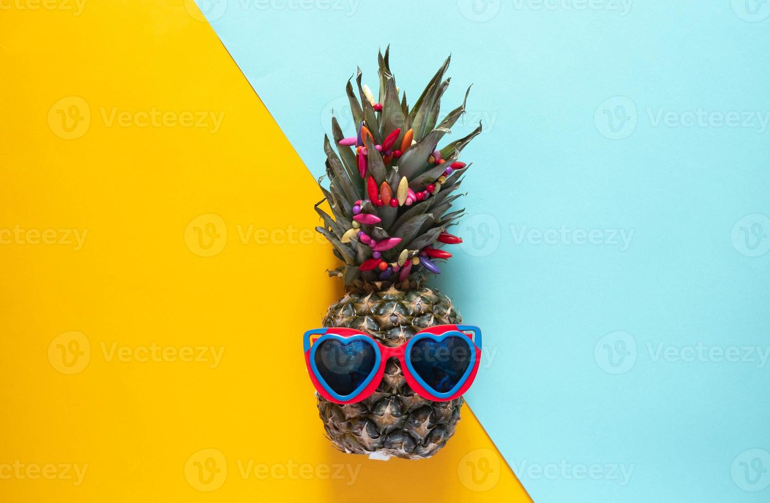 een slimme ananas in zonnebril en heldere kralen. minimaal concept, zomer tropische ananas. foto