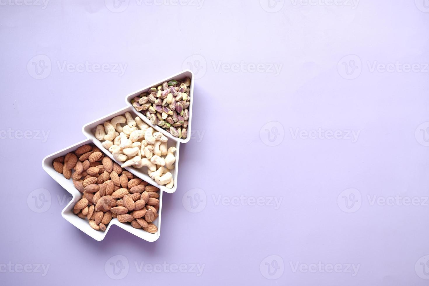 walnoot, cashewnoot en amandel in een container op tafel foto