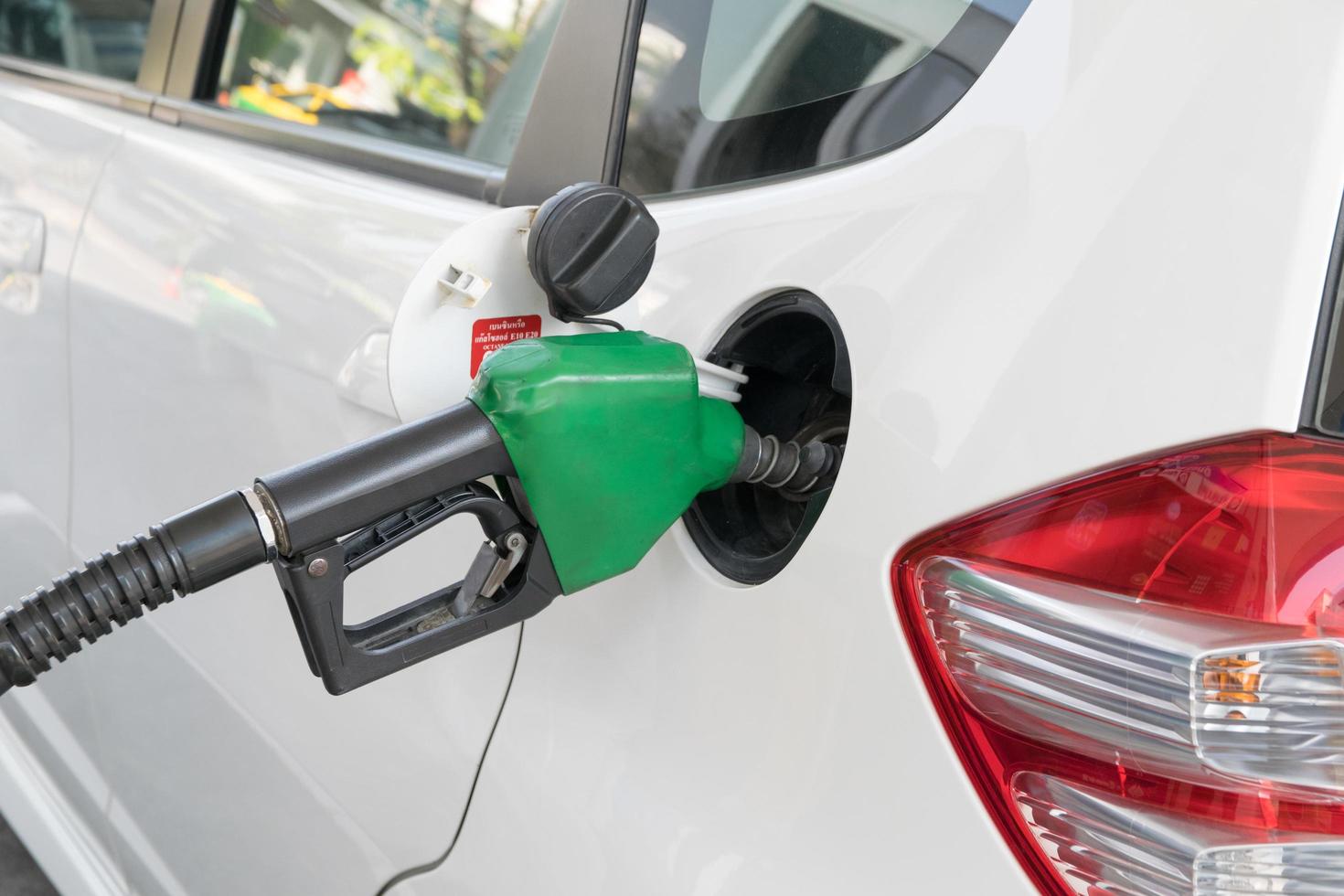 brandstofmondstuk om brandstof in de auto bij het tankstation toe te voegen foto