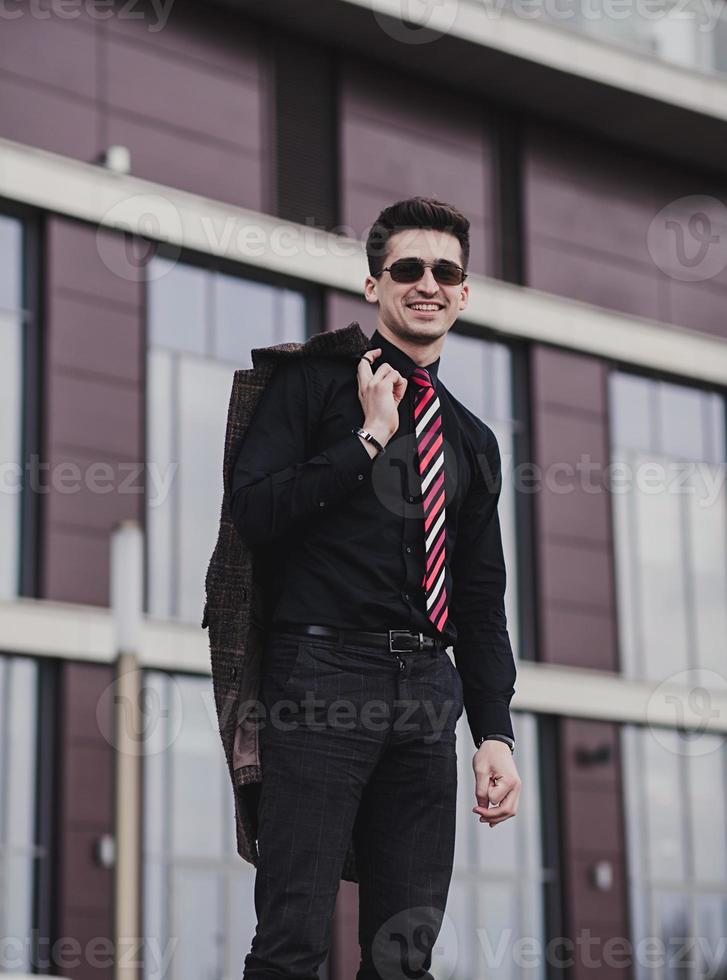 succesvolle man in een zwart shirt en jas foto