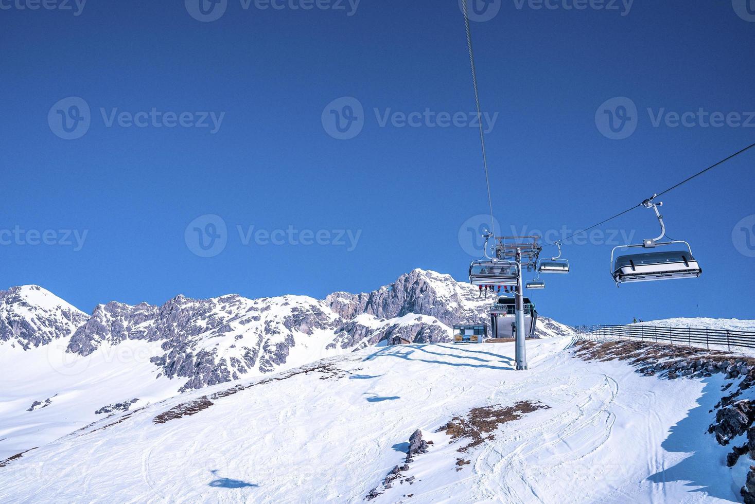 skilift op prachtige besneeuwde berg tegen blauwe lucht foto