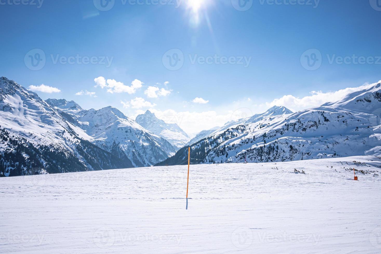 zonnige dag op besneeuwde bergen in de Alpen foto