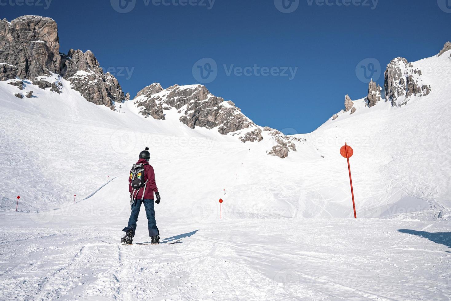 skiër snowboarden op besneeuwde berg op zonnige dag foto