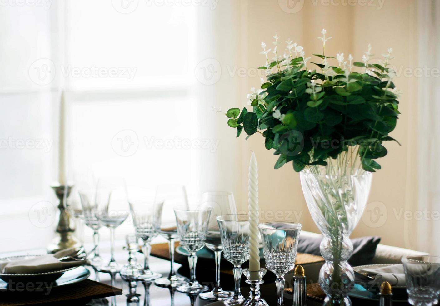 decoratie eettafel met glas, kandelaar schotel en bloem foto