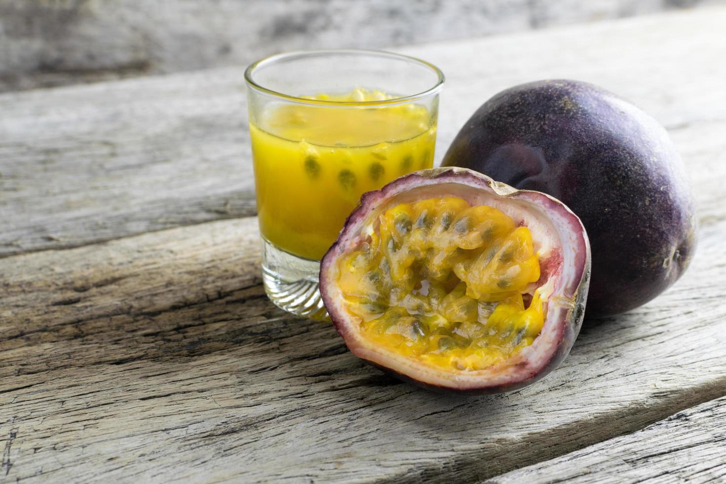 passievruchten met glas passievruchtensappen op houten foto