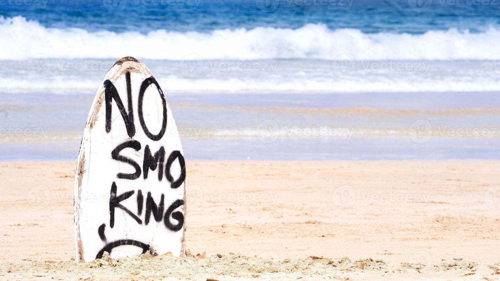 niet roken waarschuwingsbord op witte surfplank op het strand in de zomer, concept van zee milieubescherming ontwerp, kopieer ruimte, levensstijl. foto