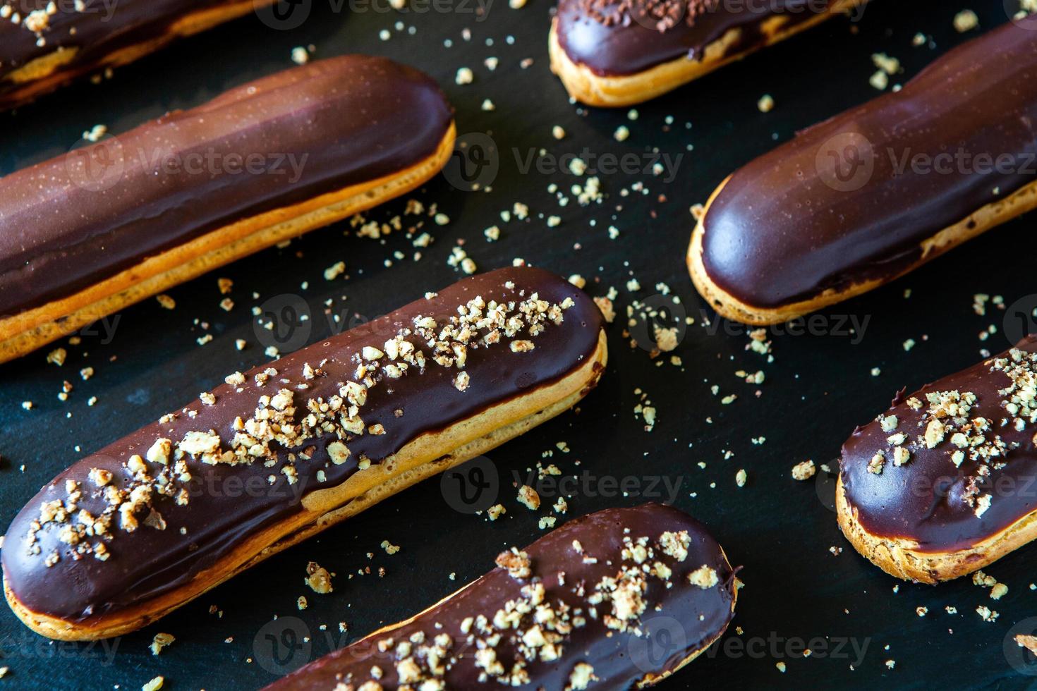 traditionele franse eclairs met chocolade. lekker toetje. zelfgemaakte cake-eclairs. zoet dessertdeeg gevuld met room. chocolade glazuur. foto