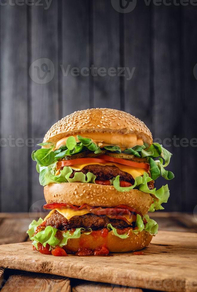 zelfgemaakte dubbele hamburger op houten achtergrond foto