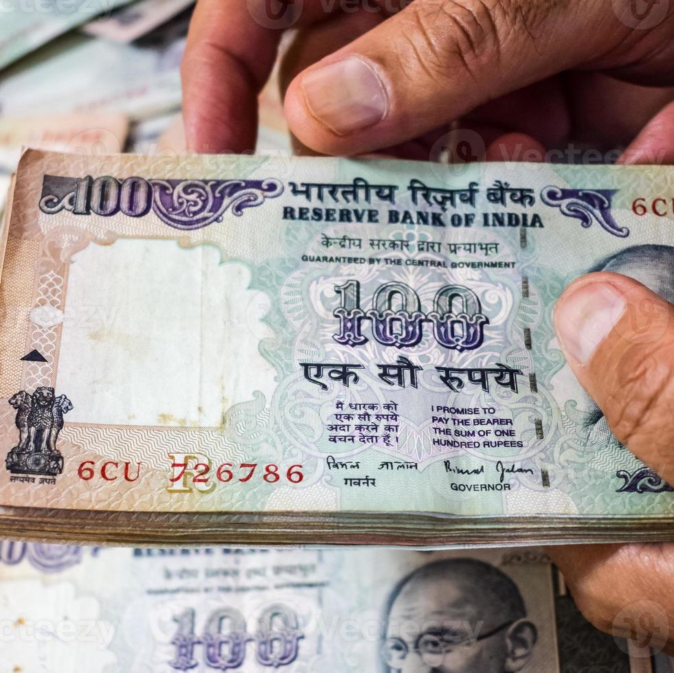 oude bankbiljetten van honderd roepie gecombineerd op tafel, Indiaas geld op de draaiende tafel. oude Indiase bankbiljetten op een roterende tafel, Indiase valuta op tafel foto