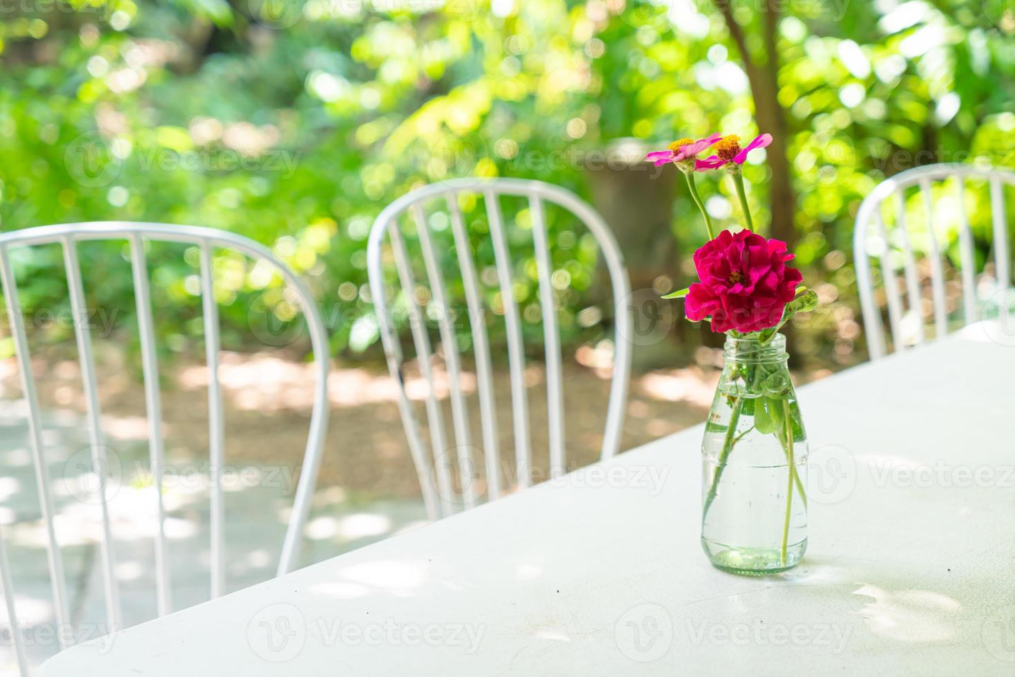 mooie roze bloem in vaas versierd op tafel foto