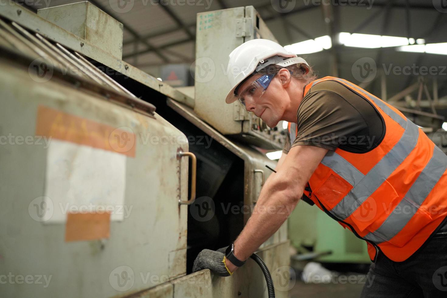 onderhoudstechnici werken voor de geautomatiseerde reparatie van cnc-machines aan een onderhoudschecklist aan de productielijn. foto