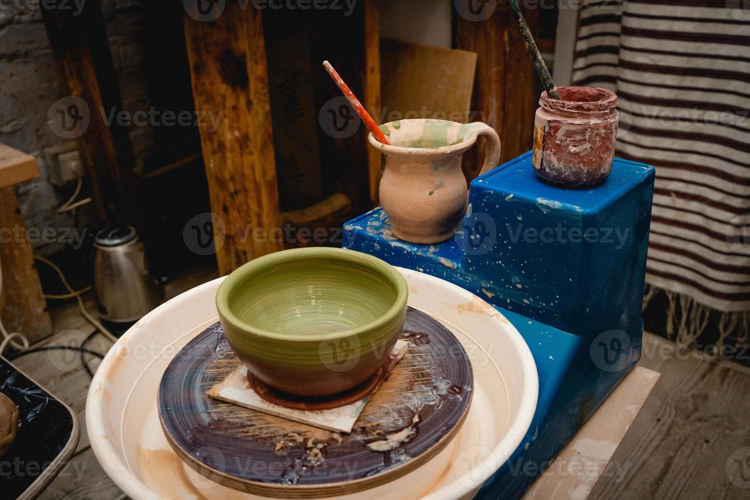 pottenbakker bezig met pottenbakkerswiel met klei. proces van het maken van keramisch servies in de pottenbakkerij. foto