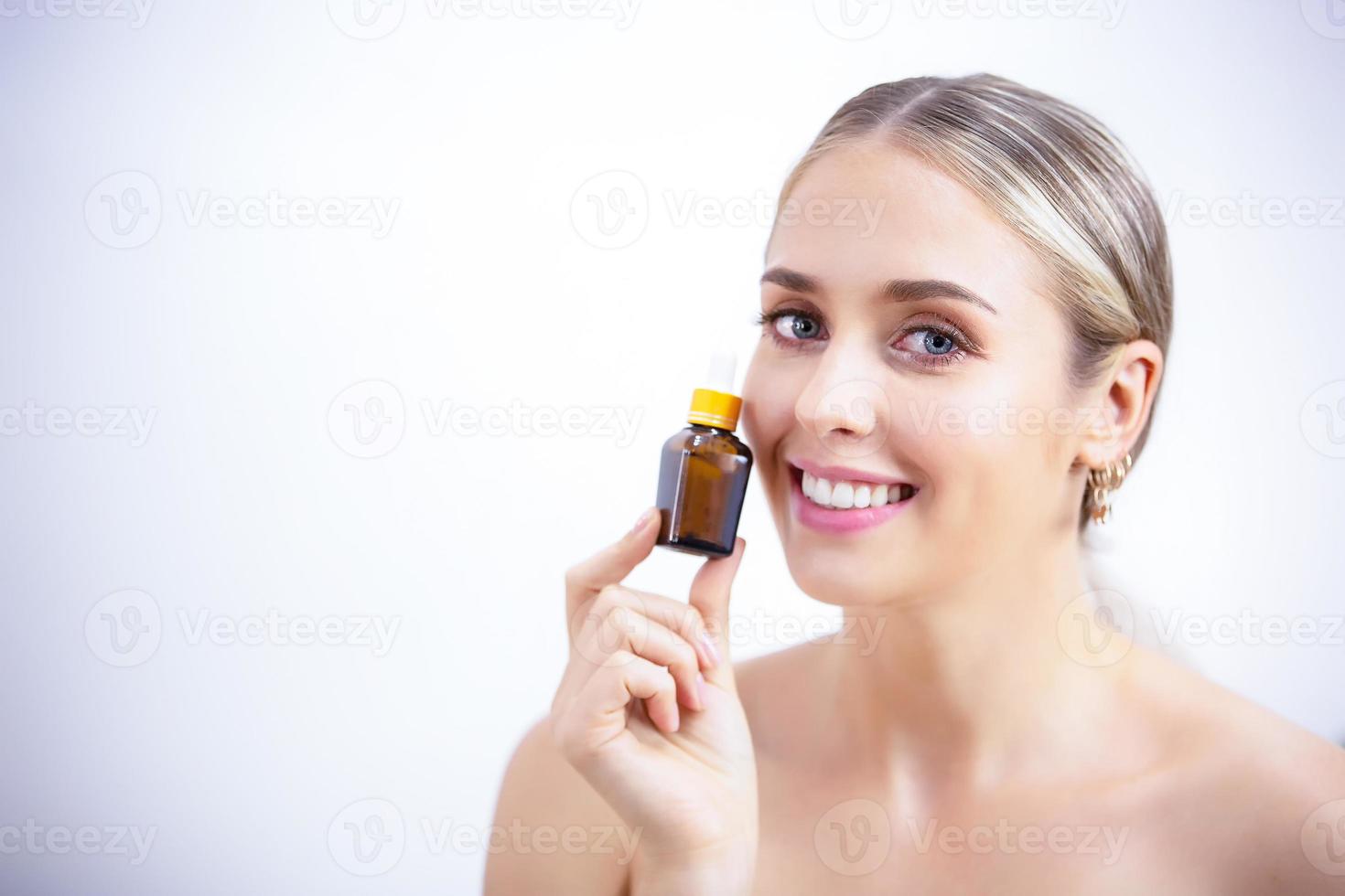 portret van lachende jonge vrouw met huidverzorging over witte grijze achtergrond foto