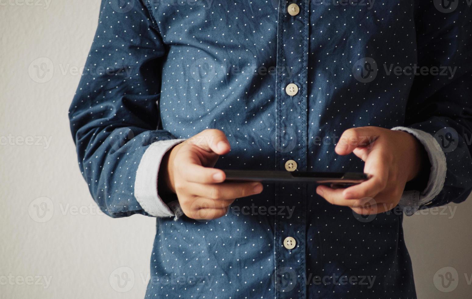 jongen die spelletjes speelt op smartphones, jongenshand die een smartphone vasthoudt foto