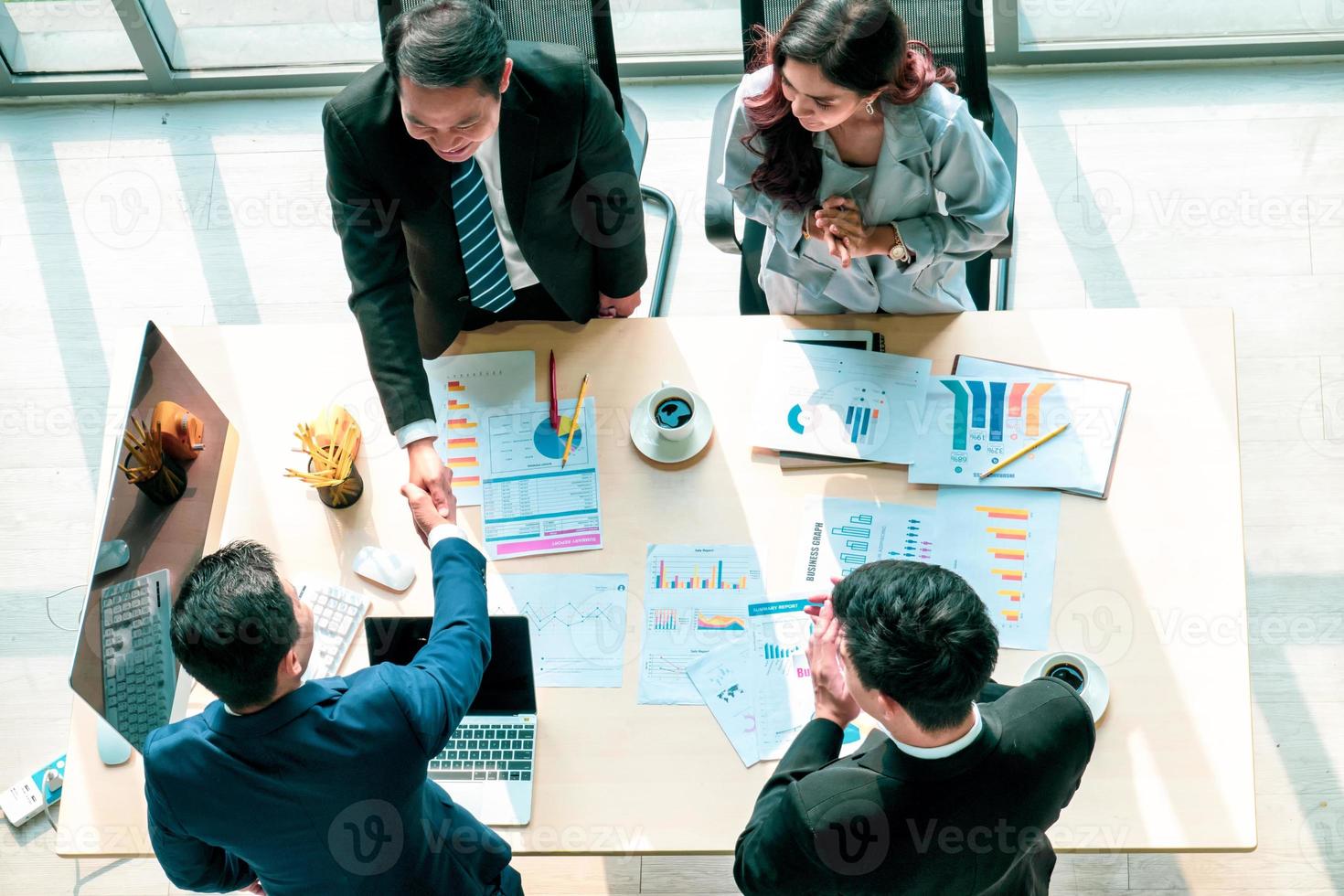 bovenaanzicht op een groep zakenman en zakenvrouw die een vergadering heeft en een zakelijke verbintenis aangaat. foto