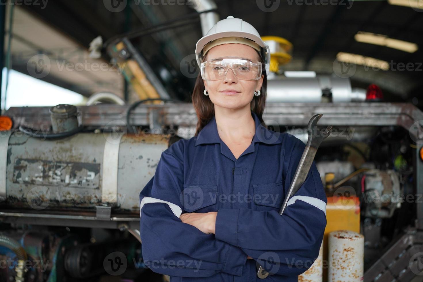 professionele jonge industriële fabrieksvrouw werknemer die met machineonderdeel werkt, industriële apparatuur en robotarmen controleert en test in grote elektrische elektronicadraad en fabriek foto